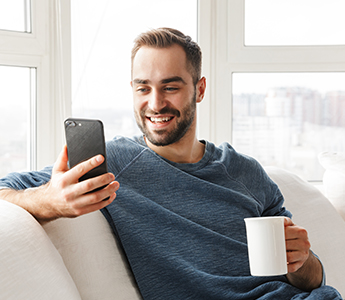 Hombre tomando cafe y viendo celular